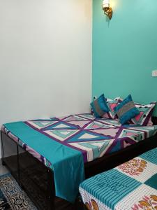 a bedroom with a bed with a colorful comforter at Hotel Tejas in Gupta Kāshi +27 photos