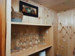a row of wine glasses on a wooden shelf at Casa Maitö in Senarega