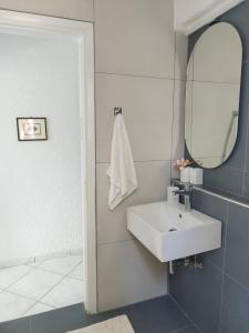 y baño con lavabo blanco y espejo. en Villa Danai, en Toroni