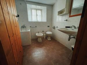 y baño con aseo y lavamanos. en Casa Maitö, en Senarega