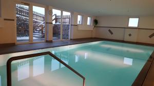 a swimming pool in a building with windows at Ferienhaus Berger in Sarntal