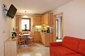 ein Wohnzimmer mit einem roten Sofa und einer Küche in der Unterkunft Ferienhaus Berger in Sarntal