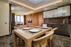 a kitchen and dining room with a table and chairs at Evin Park Suit Lara in Aksu