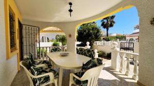 a patio with a table and chairs on a balcony at Casa Limonero by Rental Hero in Los Alcázares