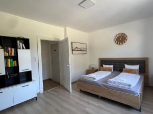 1 dormitorio con 1 cama y reloj en la pared en Wilson Paradise Guest House, en Thenneberg