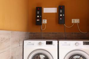 una lavandería con dos arandelas y dos teléfonos en la pared en ALBERGUE DON QUIJOTE, en Arzúa