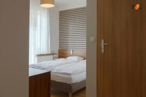 um quarto com uma cama branca e uma janela em Dom Wakacyjny MS Pro w Dźwirzynie em Dźwirzyno