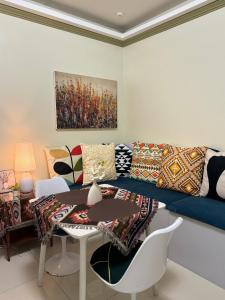 - un salon avec un canapé et une table dans l'établissement PREMIUM CONDO AT BRENTHILL BAGUIO, à Baguio