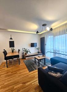 uma sala de estar com um sofá azul e uma mesa em Piernikowy Apartament 52 em Toruń