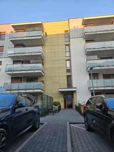 two cars parked in front of a building at Jacuzzi & Parking Piernikowy Spa Apartment by Rentoom in Toruń