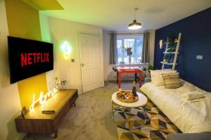 a living room with a bed and a table at The Cosy House with Free Parking, Garden and Smart TV with Netflix by Yoko Property - Perfect for Contractors, Groups & Relocation in Leamington Spa