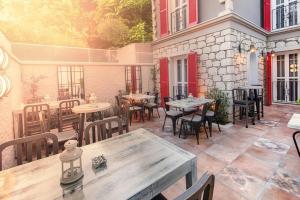 an outdoor patio with tables and chairs and a building at Petite Boutique Hotel in Ildır
