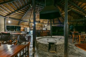 a restaurant with tables and chairs and a bar at Mziki Safari Lodge in Vaalkop Dam