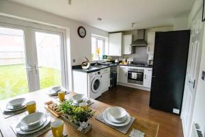 a kitchen with a table with dishes on it at The Cosy House with Free Parking, Garden and Smart TV with Netflix by Yoko Property - Perfect for Contractors, Groups & Relocation in Leamington Spa