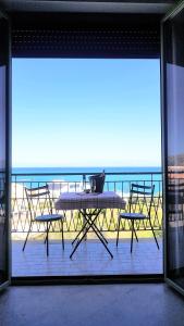 a table and chairs on a balcony with a view of the beach at La Finestra sul Golfo in Castellammare del Golfo