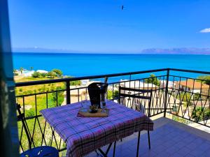 a table on a balcony with a view of the ocean at La Finestra sul Golfo in Castellammare del Golfo