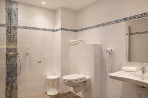 La salle de bains est pourvue de toilettes, d'une douche et d'un lavabo. dans l'établissement The Originals City, Hôtel Novella, Nantes Centre Gare, à Nantes