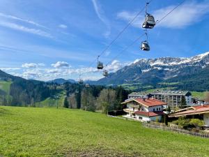 埃尔毛Apartment Berghof Ellmau的空中缆车,穿过绿地,穿过群山