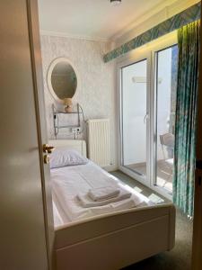 a small bedroom with a bed and a mirror at Apartment Berghof Ellmau in Ellmau