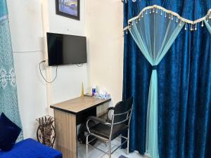 a room with a desk and a blue curtain at ASIF's Residence In Newmarket in Dhaka