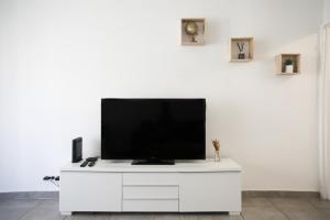 a flat screen tv on a white entertainment center at Appart Cosy sur Salon de Provence in Salon-de-Provence