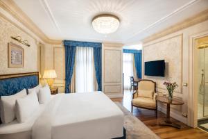 um quarto com uma grande cama branca e uma televisão em Hotel Flüela Davos - The Unbound Collection by Hyatt em Davos