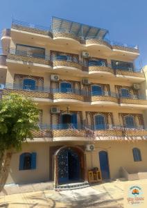 a large building with blue balconies on it at Gîte Hôtel Gezira Louxor 2 in Luxor