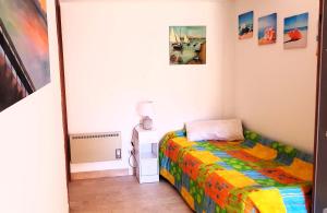 a small bedroom with a bed and paintings on the walls at La Finestra sul Golfo in Castellammare del Golfo