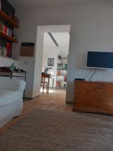 ein Wohnzimmer mit einem Bett und einem Flachbild-TV in der Unterkunft la casetta nel borgo in Ischia di Castro