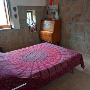 ein Schlafzimmer mit einem rosa Bett und einer Holzkommode in der Unterkunft la casetta nel borgo in Ischia di Castro