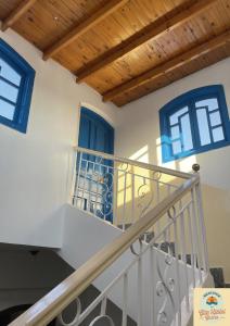 Gîte Hôtel Gezira Louxor 2 في الأقصر: درج في منزل به نوافذ زرقاء
