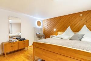 a bedroom with a large bed with a wooden headboard at Ferienwohnung zum Pavillon in Mühlenbach