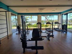 um ginásio com várias passadeiras e equipamento de exercício e janelas em Resort Praias do Lago Park em Caldas Novas
