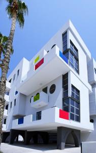 una imagen de un edificio blanco con una palmera en Alex Residence, en Lárnaca