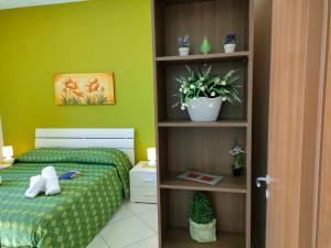 - une chambre avec un lit et un mur vert dans l'établissement Casa dell'Antico Ulivo 1 by Holiday World, à Mascali