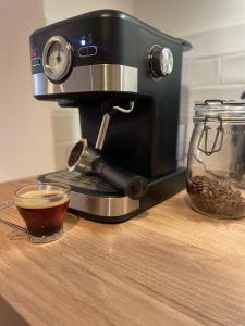 - une machine à café assise sur un comptoir avec une tasse de café dans l'établissement Les appartements d'Albertine - Pauline, à Bourges 5 autres photos