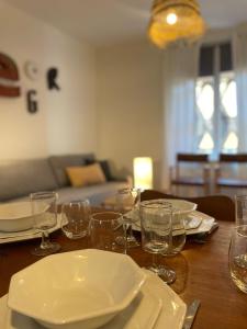une table en bois avec des assiettes et des verres dans l'établissement Les appartements d'Albertine - Pauline, à Bourges