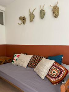 un lit avec des oreillers et des bois accrochés au mur dans l'établissement Les appartements d'Albertine - Pauline, à Bourges