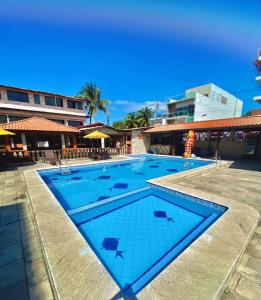 a swimming pool with blue water in a resort at Pousada Familly Porto de Galinhas in Porto De Galinhas