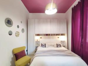 a bedroom with a large bed and a yellow chair at Suite Balilla 5 centralissima a due passi dal mare in San Benedetto del Tronto