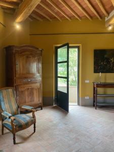 - un salon avec une chaise et une fenêtre dans l'établissement Villa Cosmiana: the gate house apartment, à Peccioli