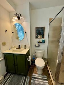 a bathroom with a toilet and a sink and a shower at Central Lake Placid Hideaway in Lake Placid