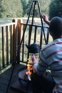 a man sitting in front of a fire pit at Eisa Yurt in York +24 photos