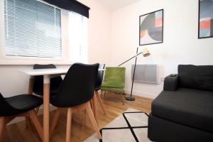 - un salon avec une table, des chaises et un canapé dans l'établissement Quaysideone bedroom apartment in Cardiff Bay, à Cardiff