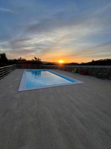 una piscina con puesta de sol en el fondo en Quinta do Esteval, en Penacova