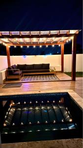 a patio with a couch under a pergola at night at Villa Sian in Punta Cana
