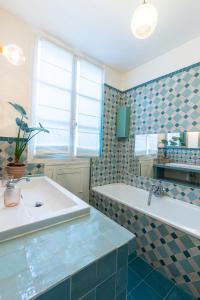 a bathroom with a tub and a sink at Marais Magique: Exclusive Apartment in Paris in Paris