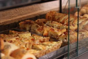 a display case filled with slices of pizza at Hotel Golden Park Uberlandia in Uberlândia