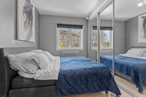 a bedroom with two beds and two windows at Central Oslo - Lovely 2 bedrooms flat with balcony in Oslo
