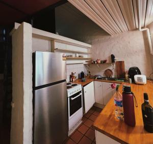 a kitchen with a stainless steel refrigerator and a stove at Cozy bedroom in terrace house in Sydney